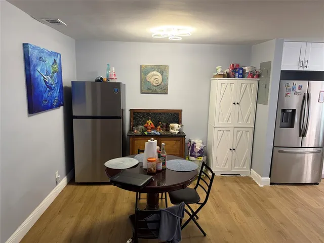 a kitchen with stainless steel appliances a refrigerator and a dining table