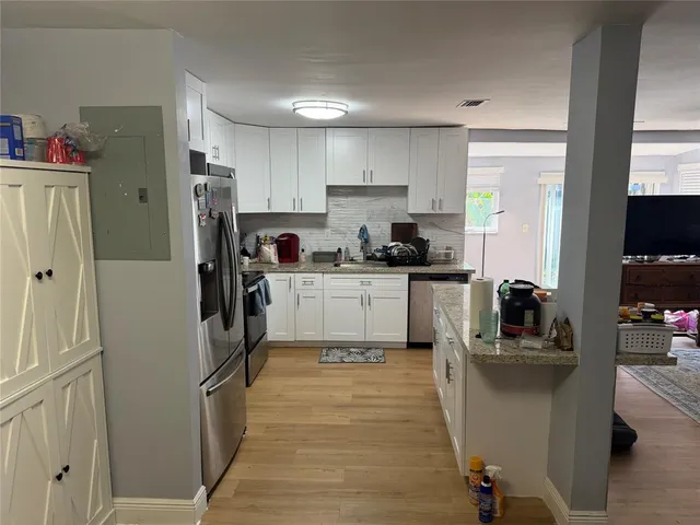 a kitchen with stainless steel appliances a refrigerator sink and cabinets