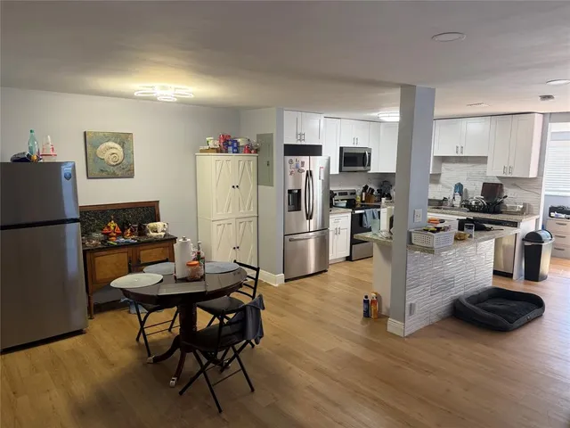 a kitchen with stainless steel appliances granite countertop a refrigerator and a stove top oven