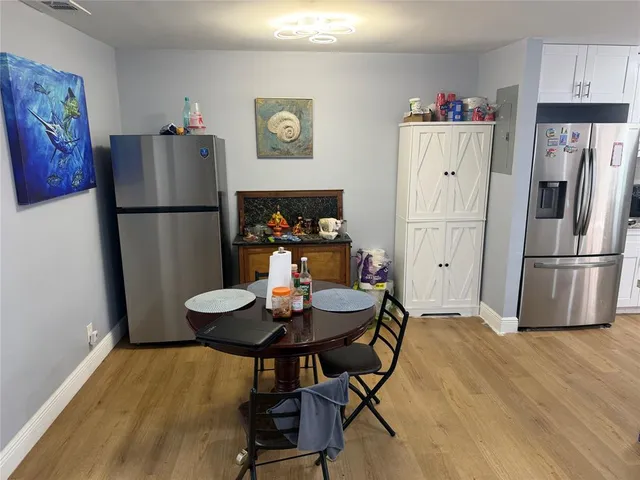 a kitchen with a refrigerator a table and chairs in it
