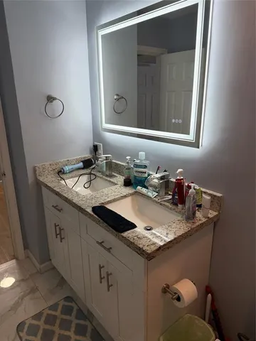 a bathroom with a granite countertop sink and a mirror