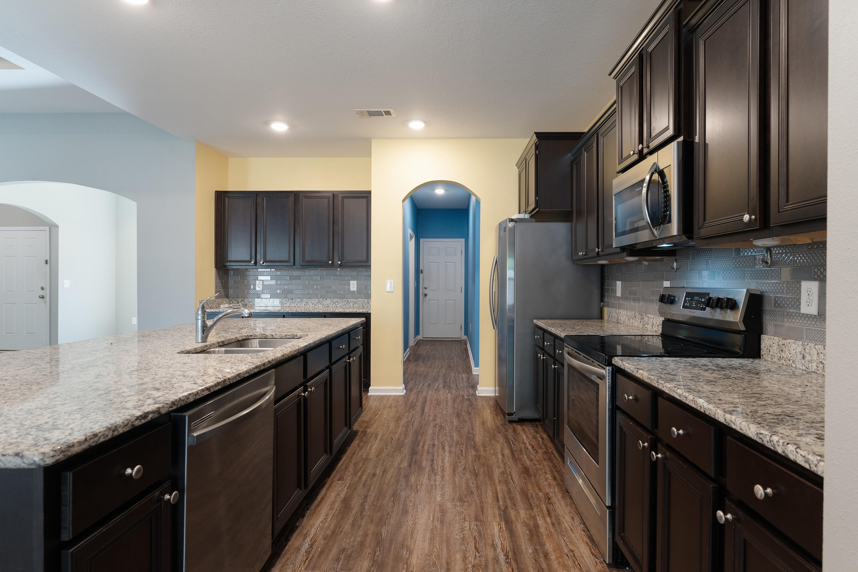 303 Merlin Court Crestview, FL 32539 - Photo 11 of 54 a kitchen with stainless steel appliances granite countertop a stove a sink and a refrigerator