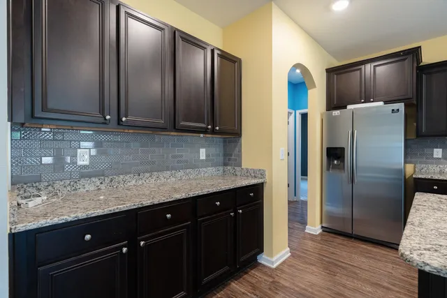 a kitchen with stainless steel appliances granite countertop a refrigerator and a sink