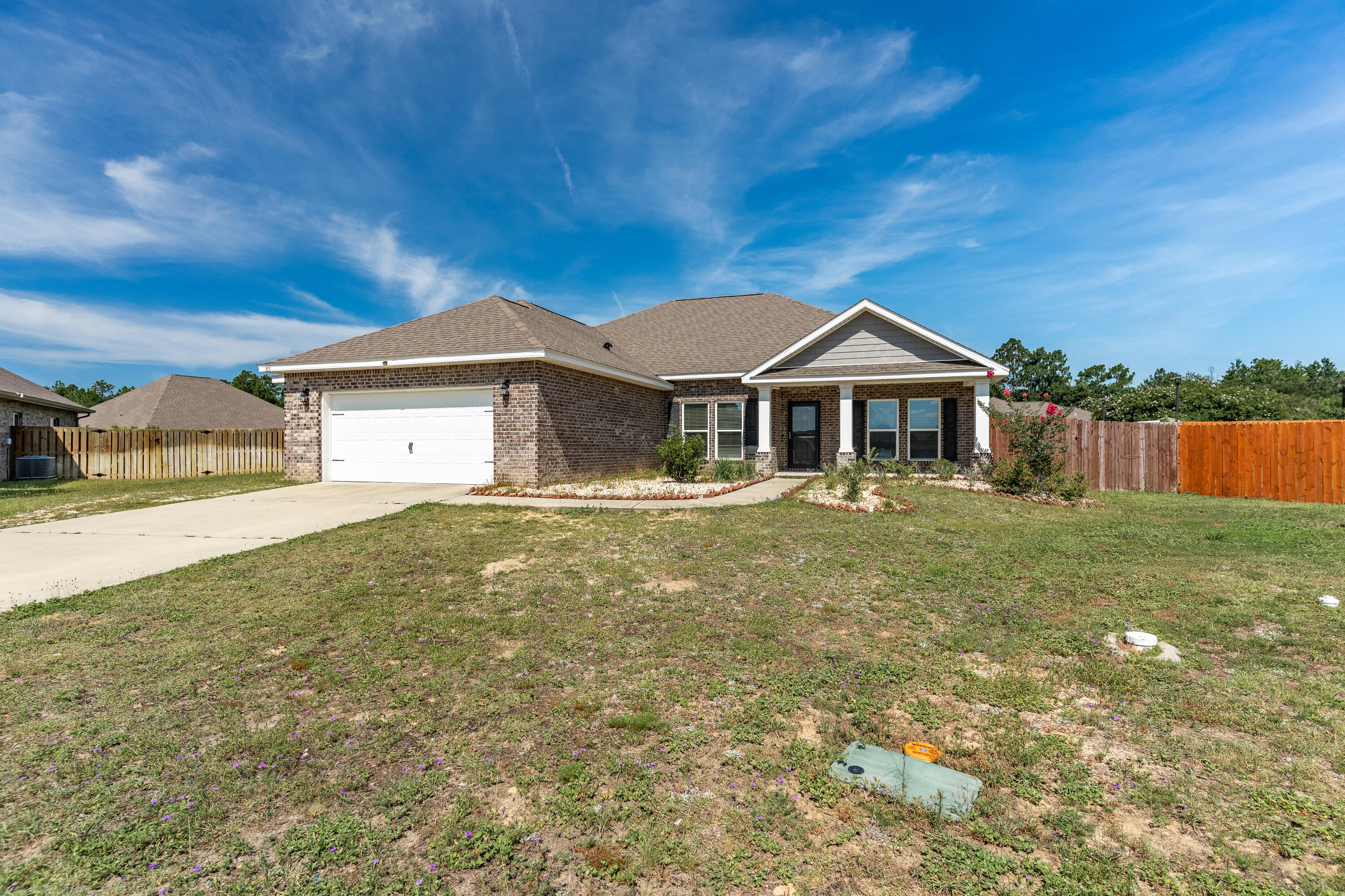 303 Merlin Court Crestview, FL 32539 - Photo 2 of 54 a front view of a house with a garden