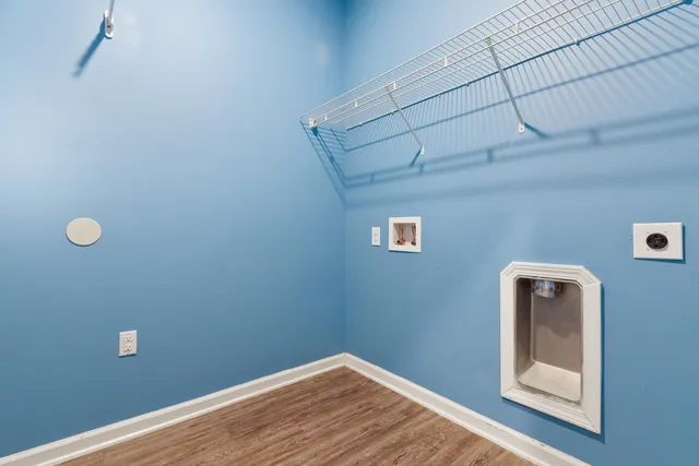 an empty room with windows and chandelier fan