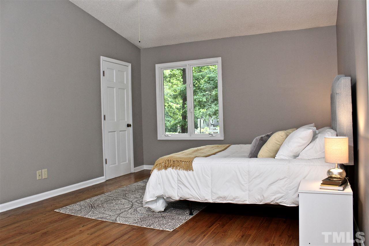 9444 Springdale Drive Raleigh, NC 27613 - Photo 11 of 25 a bedroom with a bed and wooden floor