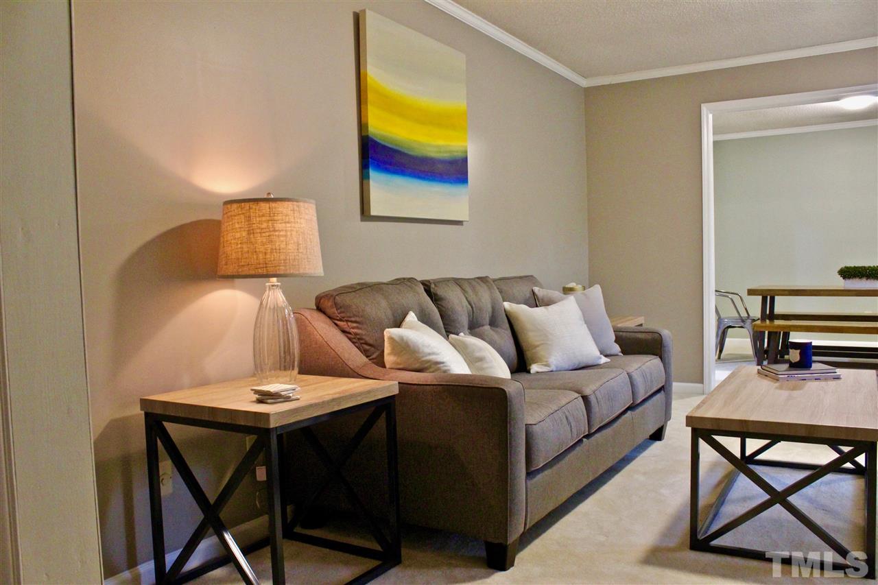 9444 Springdale Drive Raleigh, NC 27613 - Photo 12 of 25 a living room with a couch and a table