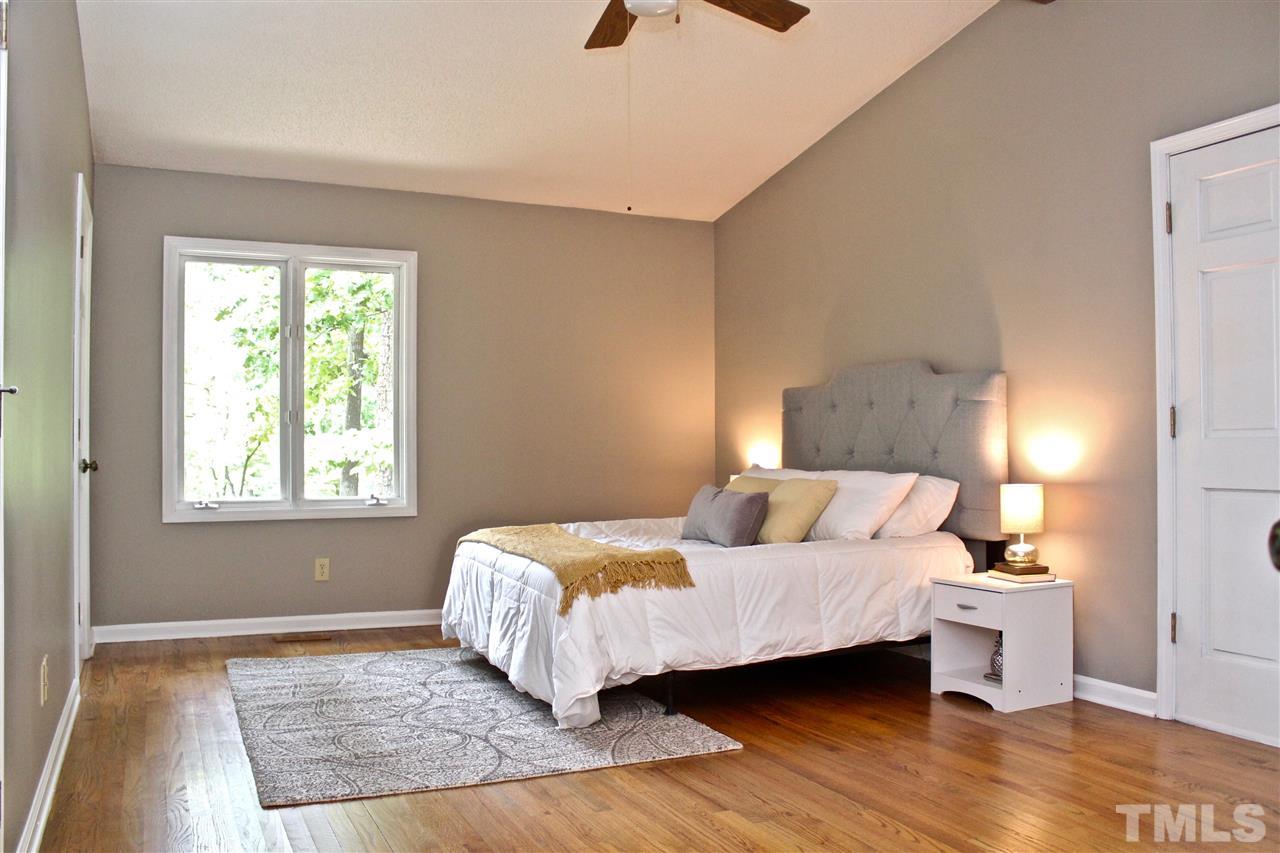 9444 Springdale Drive Raleigh, NC 27613 - Photo 3 of 25 a bedroom with a bed and wooden floor