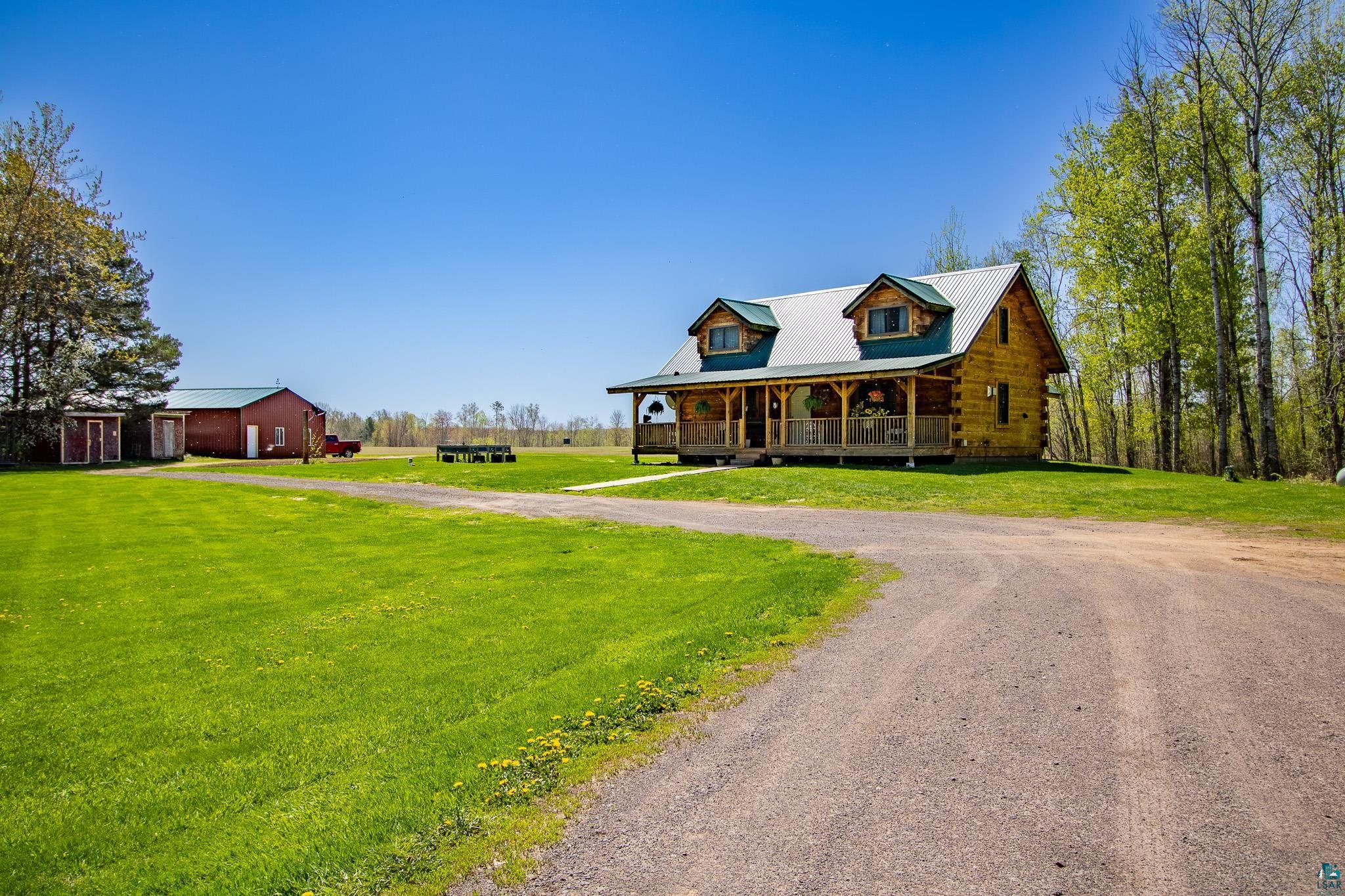 37590 Degerstrom Road Askov, MN 55704 - Photo 2 of 53 Wood log cabin featuring a covered front porch with railings, dormer windows, and a metal roof