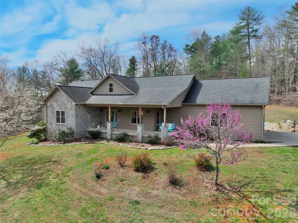 a front view of house with yard and trees in the background