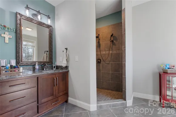 a bathroom with a double vanity sink a toilet and shower