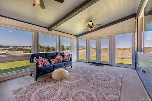 a living room with furniture and a floor to ceiling window