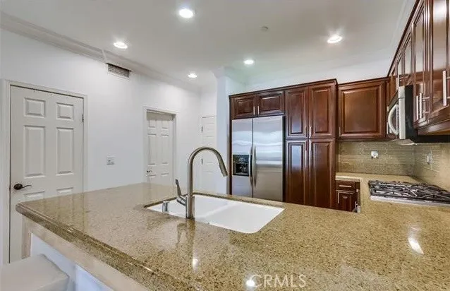 a kitchen with kitchen island a counter top a stove and a refrigerator