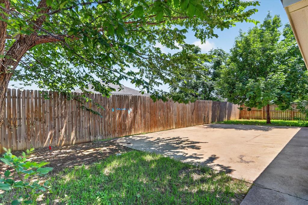 6021 Hartman Road Forest Hill, TX 76119 - Photo 26 of 27 a backyard of a house with trees and grass