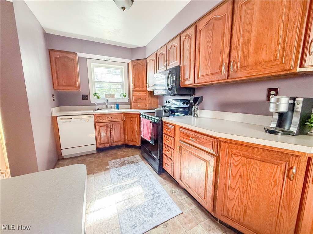 4672 Liberty Road South Euclid, OH 44121 - Photo 9 of 23 Kitchen featuring black appliances, light countertops, and brown cabinetry