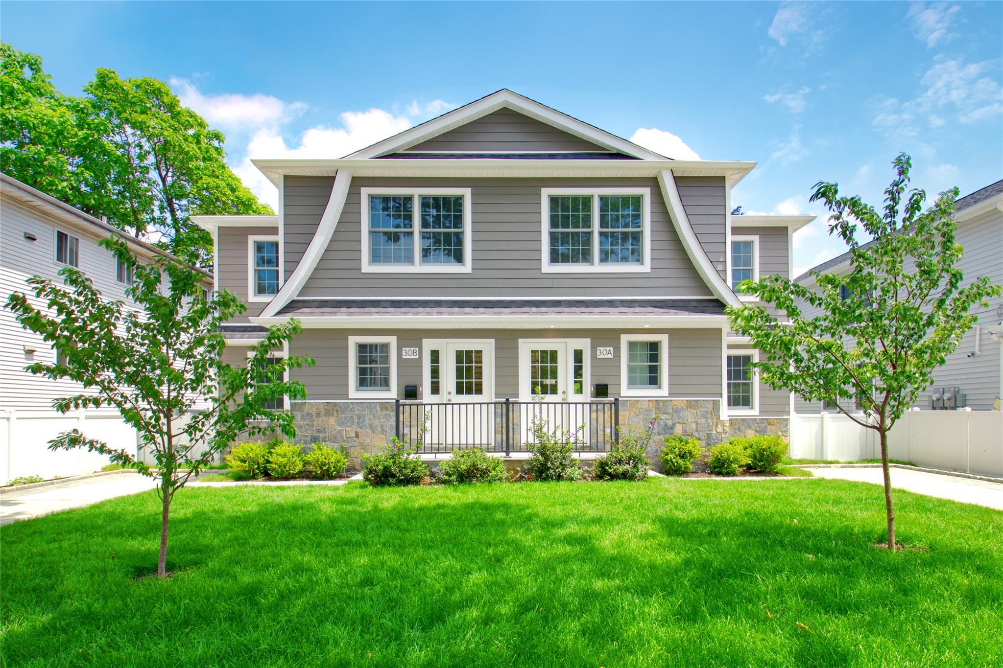 30 Kirkwood Road, Unit A AND B Port Washington, NY 11050 - Photo 1 of 1 a front view of a house with a yard and trees