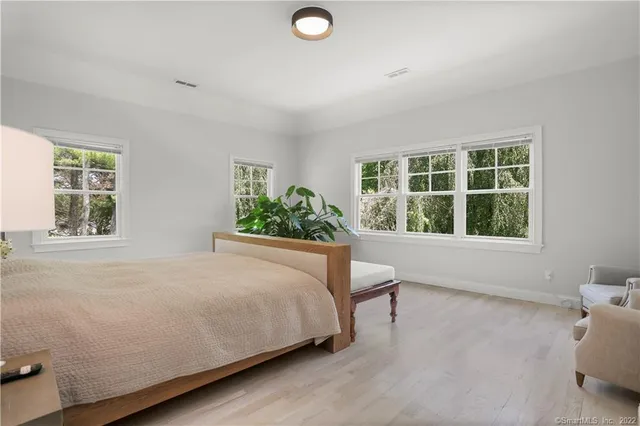 a bed sitting in a bedroom next to a window