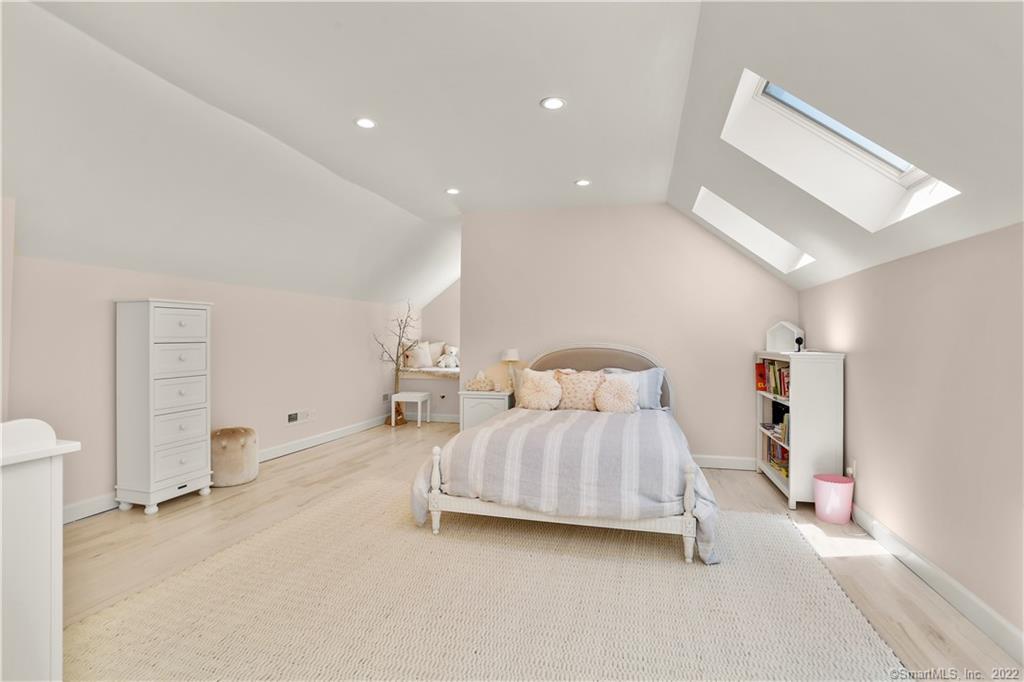 220 Burr Street Fairfield, CT 06824 - Photo 24 of 34 a bedroom with a bed and a lamp