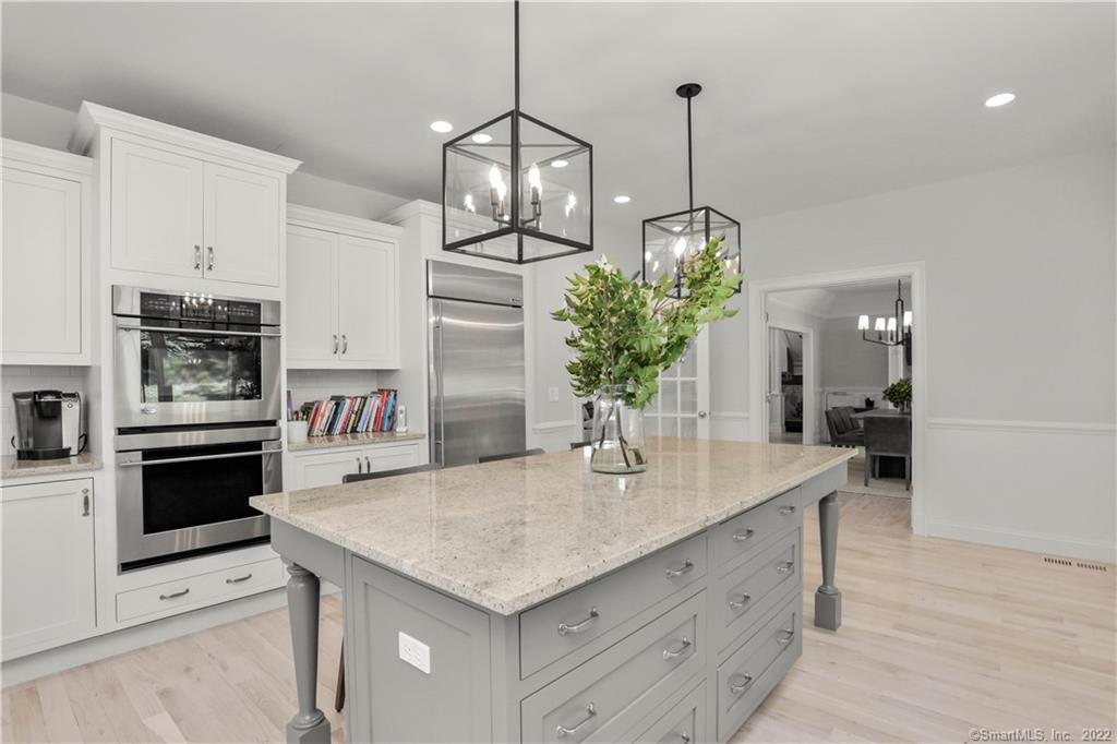 220 Burr Street Fairfield, CT 06824 - Photo 9 of 34 a kitchen with stainless steel appliances kitchen island granite countertop a stove a refrigerator and a wooden floor