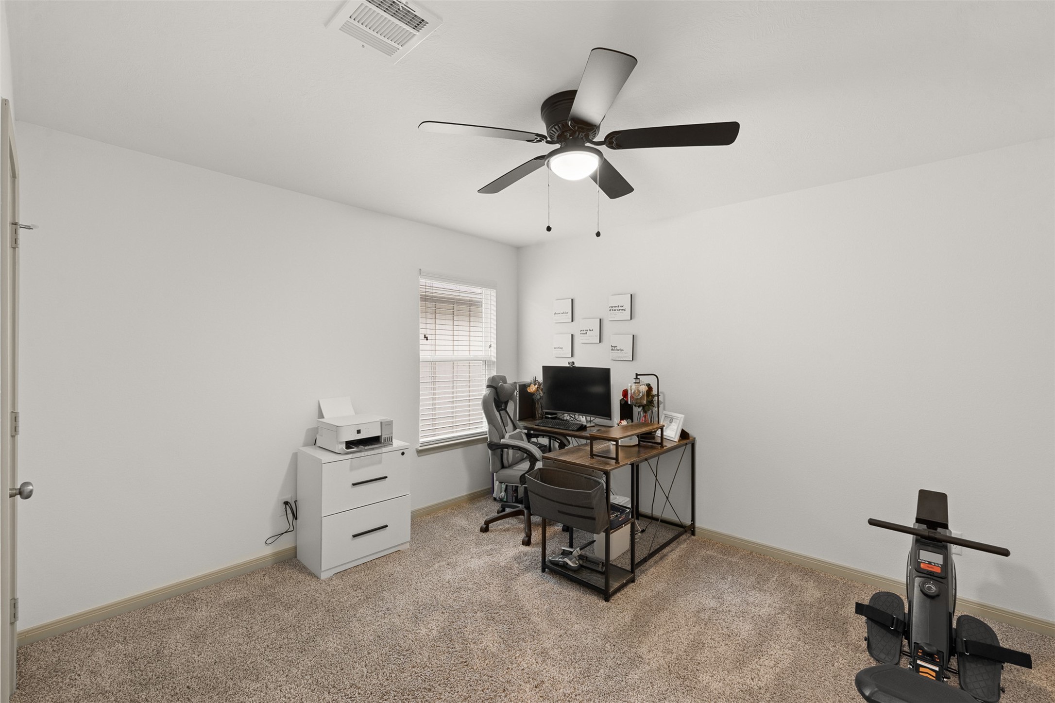 1968 Chief Street Bryan, TX 77807 - Photo 13 of 27 This photo showcases a cozy home office with neutral carpeting, a ceiling fan, and ample natural light.