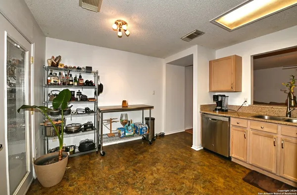 a view of a kitchen with fridge and workspace