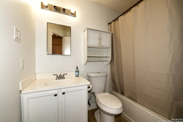 a bathroom with a toilet sink and a mirror