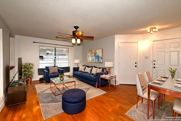 a living room with furniture a dining table and a chandelier