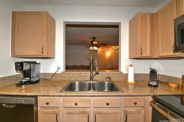 a kitchen with granite countertop a sink stainless steel appliances and cabinets