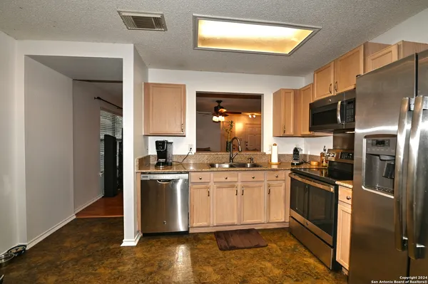 a kitchen with stainless steel appliances granite countertop a stove top oven a sink and dishwasher