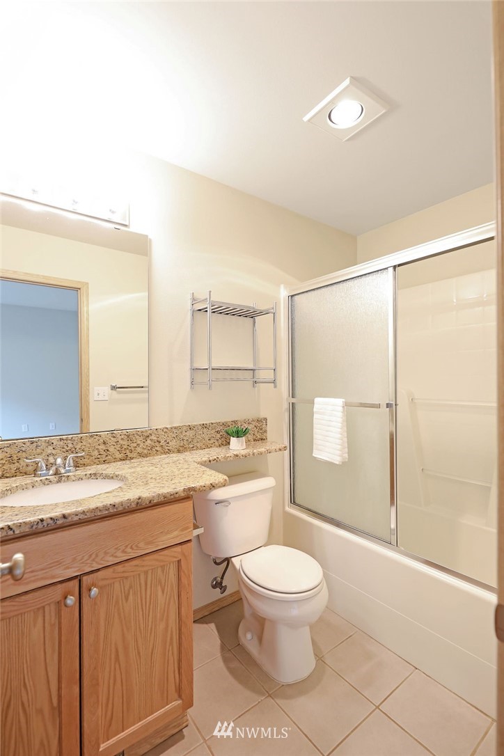2516 194th Street Southeast Bothell, WA 98012 - Photo 21 of 28 a bathroom with a granite countertop sink toilet a mirror and shower