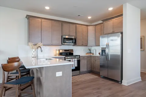 a kitchen with stainless steel appliances granite countertop a refrigerator sink and stove