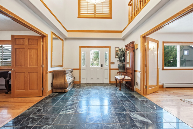 169 Taylor Road, Unit 101 Grantsville, UT 84029 - Photo 8 of 47 Main home - Grand foyer featuring dark stone tile flooring, a two-story ceiling, and natural wood trim throughout