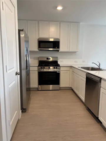 a kitchen with cabinets and a microwave