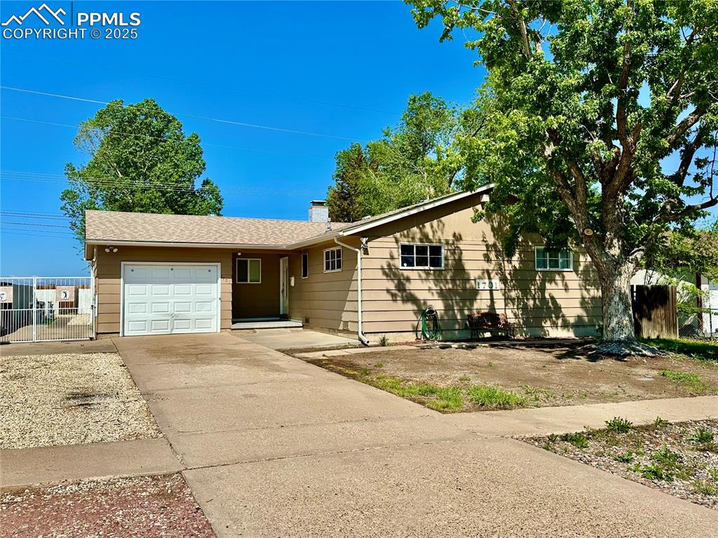1701 Jerry Murphy Road Pueblo, CO 81001 - Photo 2 of 20 Ranch-style house with an attached garage, concrete driveway, fence, and a chimney