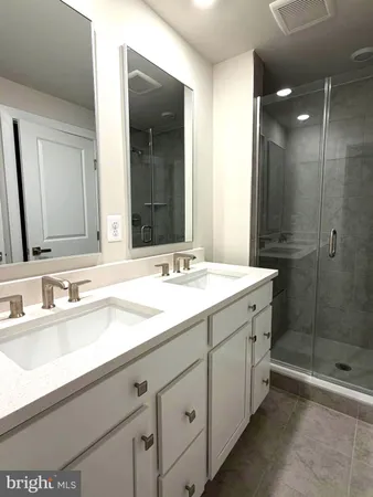 a bathroom with a shower sink and mirror