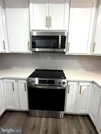 a kitchen with granite countertop a stove and a microwave