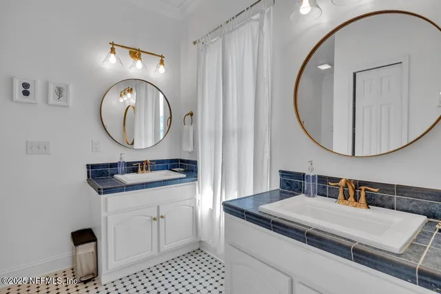 a bathroom with a double vanity sink and a mirror