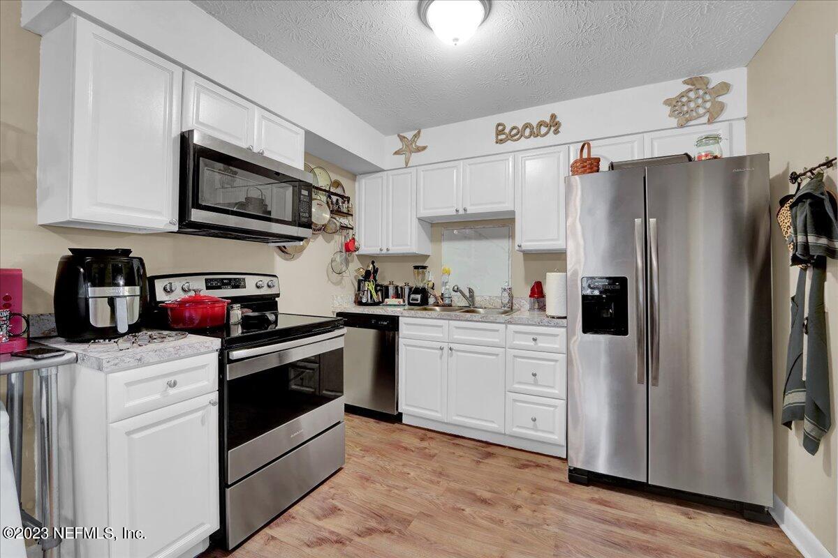 1975 Talladega Road Jacksonville, FL 32209 - Photo 5 of 15 a kitchen with stainless steel appliances granite countertop a refrigerator sink and stove