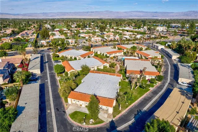 an aerial view of residential houses with outdoor space and swimming pool