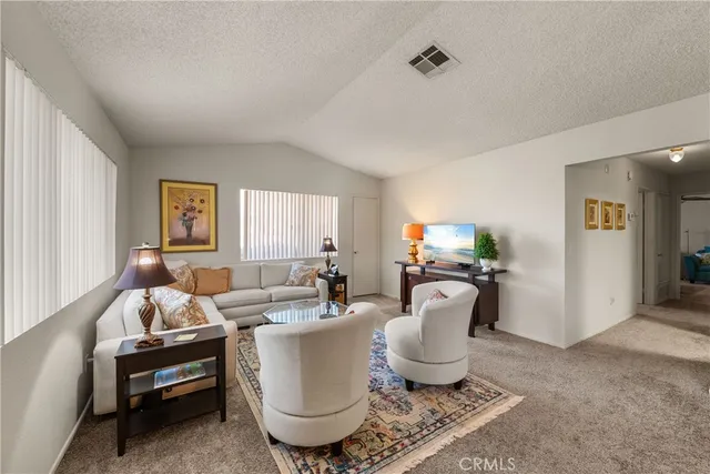 a living room with furniture a window and a potted plant