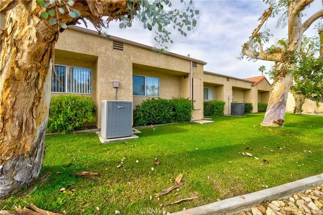 a view of a house with a yard and pathway