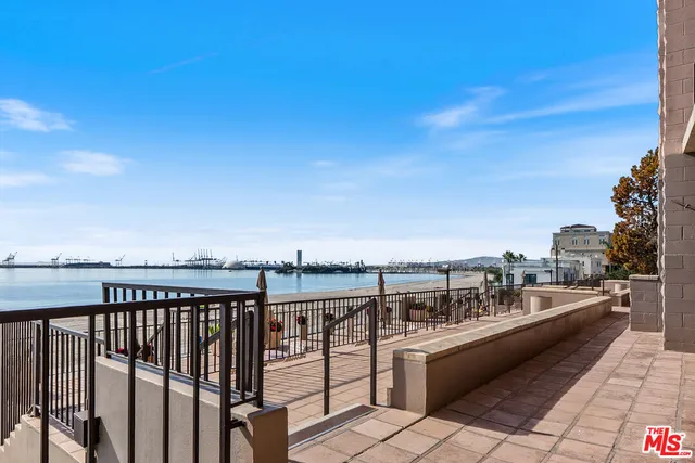 a view of roof deck with two chairs and iron fence