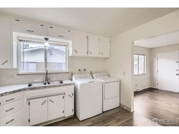 a utility room with cabinets washer and dryer