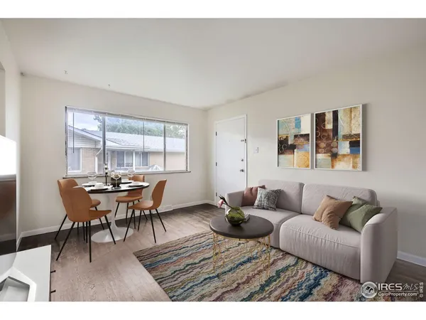 a living room with furniture wooden floor and a window