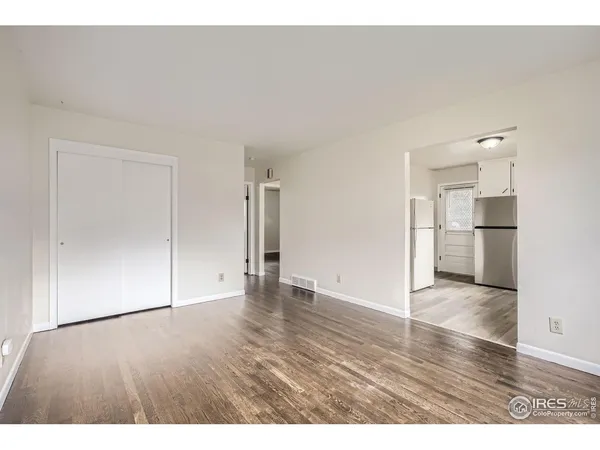 a view of empty room with wooden floor
