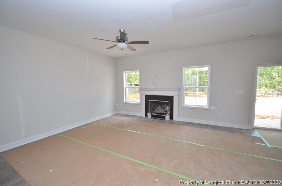 822 Quewhiffle Road Aberdeen, NC 28315 - Photo 2 of 7 an empty room with windows and fireplace
