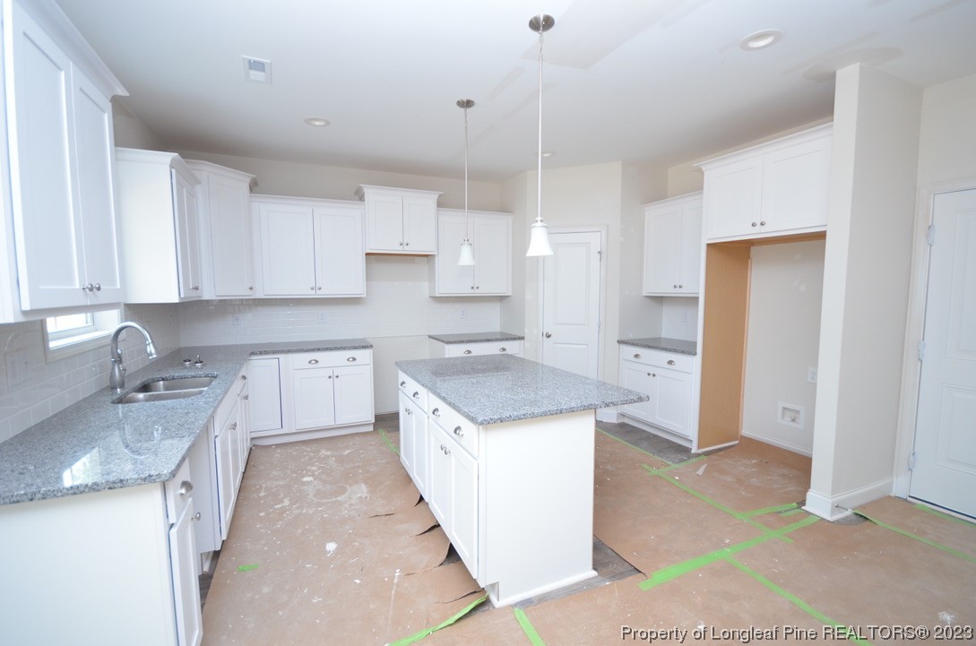 822 Quewhiffle Road Aberdeen, NC 28315 - Photo 4 of 7 a kitchen with a stove sink and cabinets