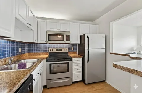 a car parked in front of a house next to a yard