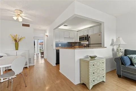a living room with furniture a dining table and a stove with wooden floor