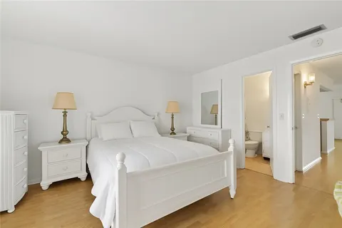 a bedroom with a bed and flat tv screen on dresser
